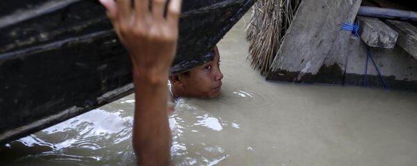 A boy moves his boat in a flooded village outside Zalun Township, Irrawaddy Delta, Myanmar - Sputnik Afrique
