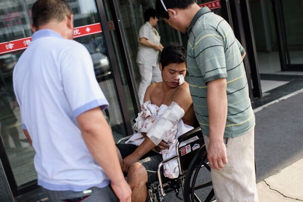 A man waits in a wheelchair after receiving treatment at Gangkou hospital in Tianjin following a series of explosions at a warehouse in the northern Chinese city on August 13, 2015. - Sputnik Afrique