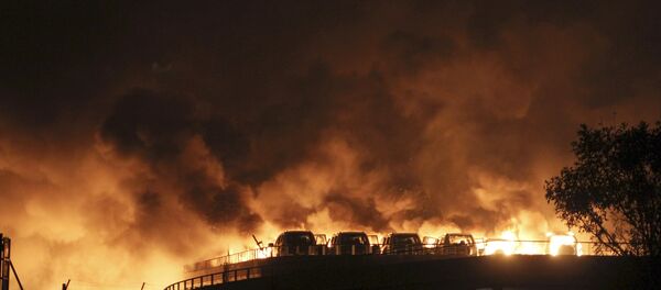 Vehicles are seen burning after blasts at Binhai new district in Tianjin municipality, China, August 13, 2015. - Sputnik Afrique