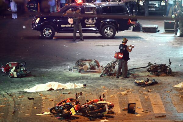 A policeman photographs debris from an explosion in central Bangkok, Thailand, Monday, Aug. 17, 2015. - Sputnik Afrique