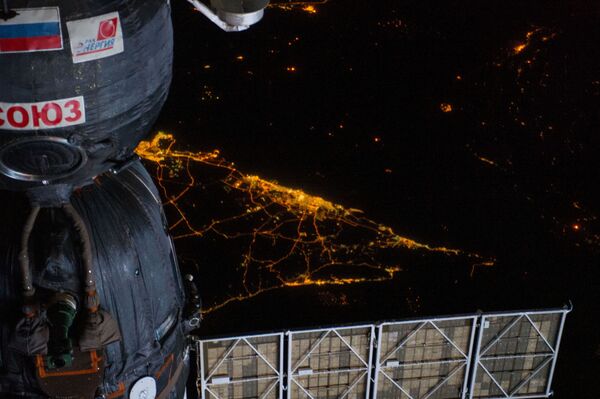 Корабль Союз на фоне ночного вида Земли с борта МКС - Sputnik Afrique