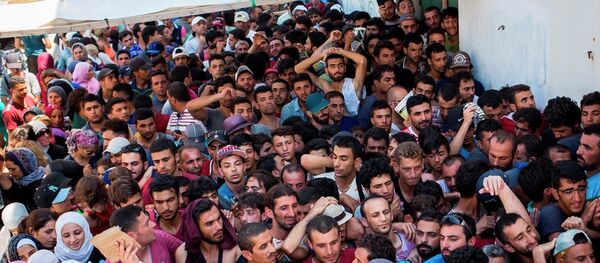 Syrian migrants and refugees gather at a makeshift migrant detention center at Kos' abandoned football stadium after crossing from Turkey, at the southeastern island of Kos, Greece, Wednesday, Aug. 12, 2015. Syrian migrants and refugees gather at a makeshift migrant detention center at Kos' abandoned football stadium after crossing from Turkey, at the southeastern island of Kos, Greece, Wednesday, Aug. 12, 2015. - Sputnik Afrique