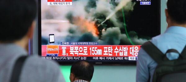 Люди смотрят выпуск новостей об обстреле южнокорейских военных армией КНДР - Sputnik Afrique