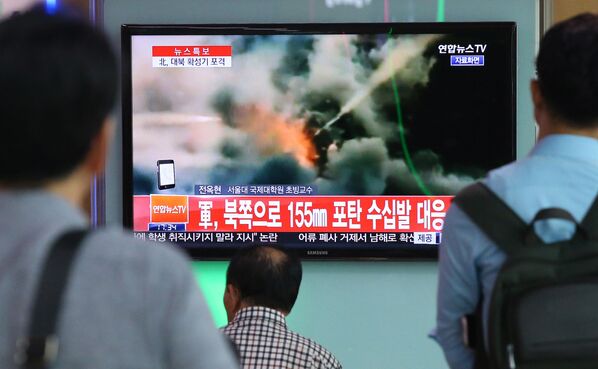 Люди смотрят выпуск новостей об обстреле южнокорейских военных армией КНДР - Sputnik Afrique