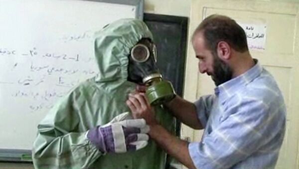 un bénévole portant une masques à gaz apprennent comment réagir face à une attaque chimique, Alep, Syrie - Sputnik Afrique
