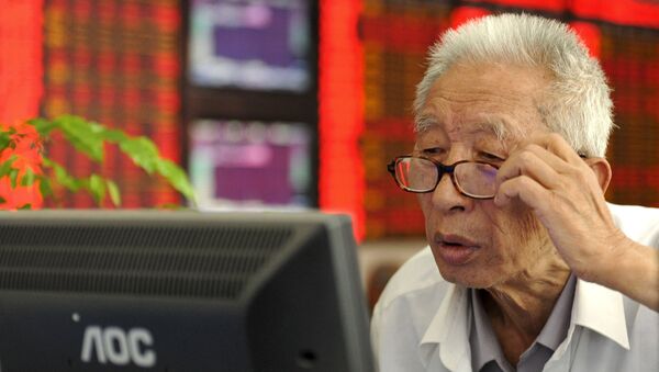 An investor adjusts his glasses as he looks at a computer screen in front of an electronic board showing stock information at a brokerage house in Fuyang, Anhui province, China, July 9, 2015. - Sputnik Afrique