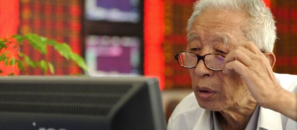 An investor adjusts his glasses as he looks at a computer screen in front of an electronic board showing stock information at a brokerage house in Fuyang, Anhui province, China, July 9, 2015. - Sputnik Afrique