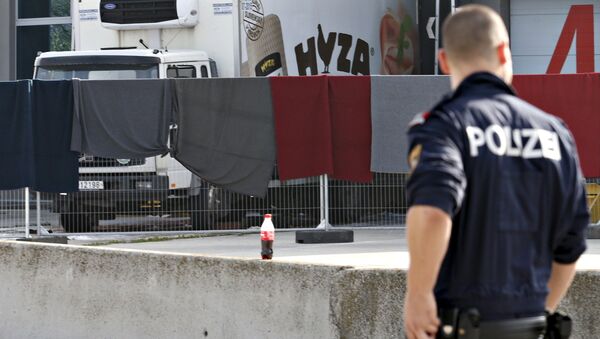 Un officier de police examine le camion où des corps de 71 migrants ont été trouvés jeudi 27 août 2015, Autriche - Sputnik Afrique