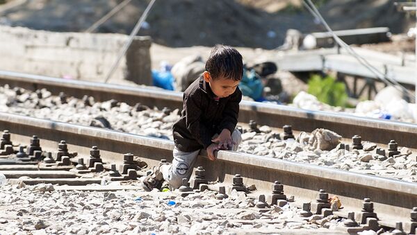 Мальчик сидит на рельсах неподалеко от границы Греции и Македонии - Sputnik Afrique