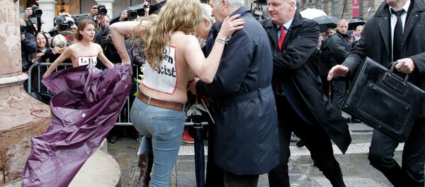 Femen activists with Le Pen Top Fascist painted on their bodies appear as France’s far-right National Front president Marine Le Pen places a wreath at Joan of Arc statue during its annual May Day march, in Paris, France, Friday, May 1, 2015 Femen activists with Le Pen Top Fascist painted on their bodies appear as France’s far-right National Front president Marine Le Pen places a wreath at Joan of Arc statue during its annual May Day march, in Paris, France, Friday, May 1, 2015 - Sputnik Afrique