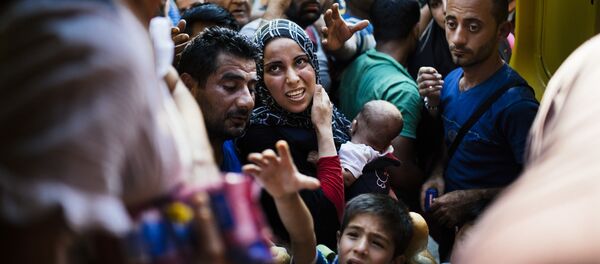 Мигранты в ожидании раздачи еды от македонских волонтеров на железнодорожной станции Гевгелия на македонско-греческой границе - Sputnik Afrique