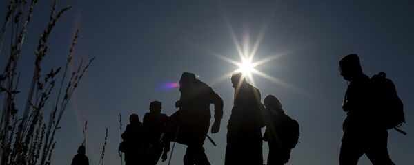 Migrants walk towards a makeshift camp at a collection point in the village of Roszke, Hungary, September 7, 2015. - Sputnik Afrique