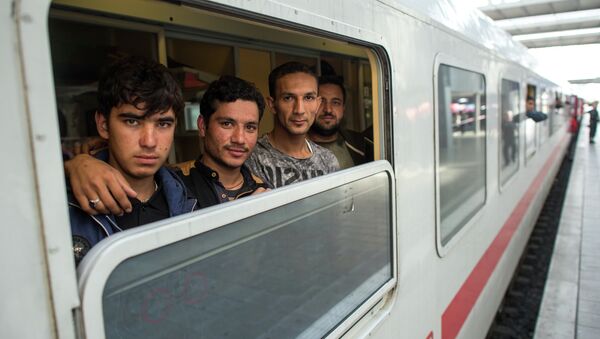 Friends Ibrahim, Hamayoun and Nomi, from left, refugees from Afghanistan, travel in a special train to Dortmund, photographed at the central train station in Munich, Germany, Friday Sept. 11, 2015. - Sputnik Afrique