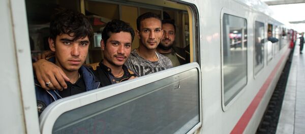Friends Ibrahim, Hamayoun and Nomi, from left, refugees from Afghanistan, travel in a special train to Dortmund, photographed at the central train station in Munich, Germany, Friday Sept. 11, 2015. - Sputnik Afrique