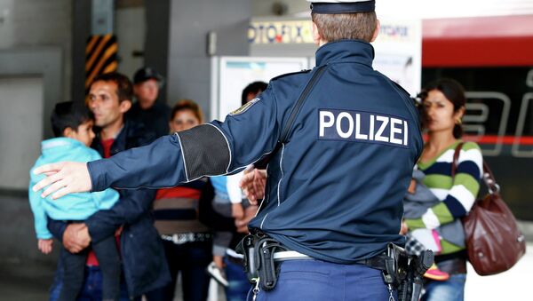 Un officier de police allemand indique la voie aux migrants arrivés le 7 septembre dernier à la gare de Munich. - Sputnik Afrique