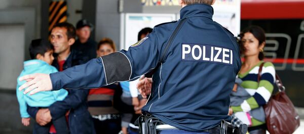 Un officier de police allemand indique la voie aux migrants arrivés le 7 septembre dernier à la gare de Munich. - Sputnik Afrique