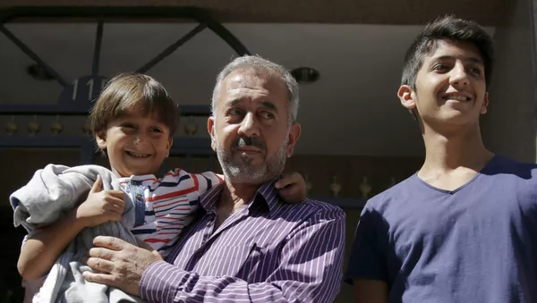 Osama Abdul Mohsen avec s fils dans les mains, le 16 septembre - Sputnik Afrique
