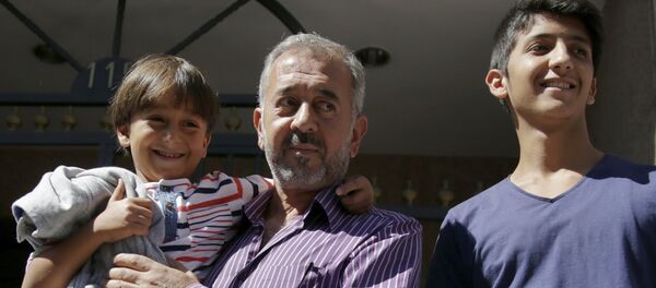 Osama Abdul Mohsen avec s fils dans les mains, le 16 septembre - Sputnik Afrique