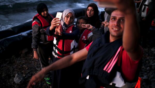 Des réfugiés syriens se prennent en photo en arrivant dans l'île grecque de Lesbos - Sputnik Afrique