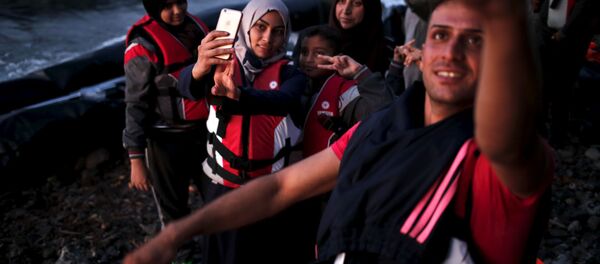 Des réfugiés syriens se prennent en photo en arrivant dans l'île grecque de Lesbos - Sputnik Afrique