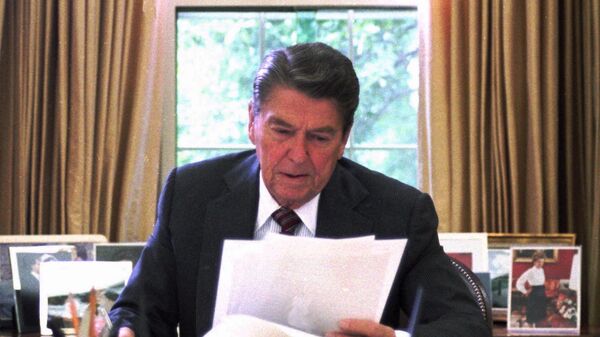 President Ronald Reagan poses for photographers after his address to the nation from the Oval Office on Oct. 15, 1987. [AP file / Barry Thumma] - Sputnik Africa