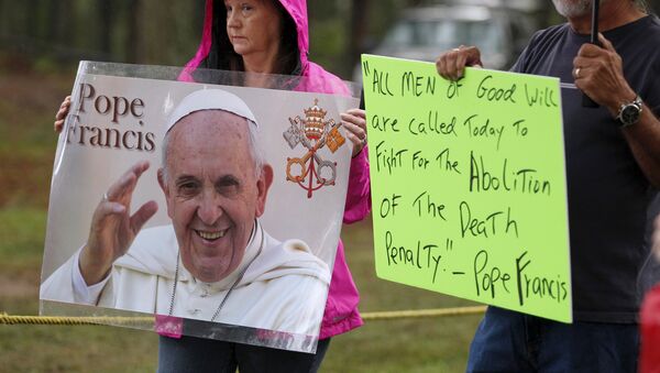 Supporters of Kelly Gissendaner hold signs with an image and quote from Pope Francis as they wait for the execution of Gissendaner at the Georgia Diagnostic and Classification Prison in Jackson, Georgia September 29, 2015 - Sputnik Afrique