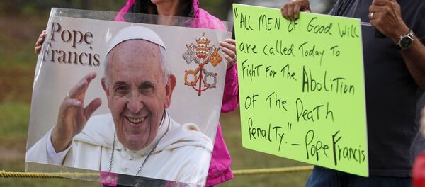 Supporters of Kelly Gissendaner hold signs with an image and quote from Pope Francis as they wait for the execution of Gissendaner at the Georgia Diagnostic and Classification Prison in Jackson, Georgia September 29, 2015 - Sputnik Afrique