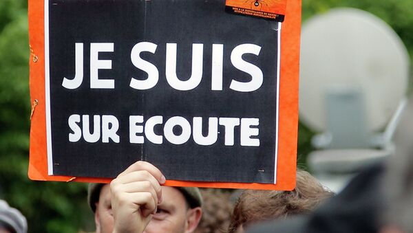 A demonstrator holds a placard that reads: I am on Record, during a gathering at Invalides, Paris, to protest against the emergency government surveillance law, Monday, May 4, 2015. - Sputnik Afrique