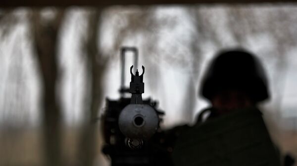 Un soldat tient une mitrailleuse lourde à un poste de contrôle de l'armée ukrainienne près de Kurakhovo, en Ukraine, le 3 mars 2015 - Sputnik Afrique