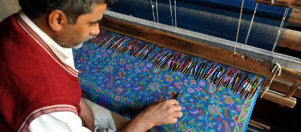 A Kashmiri artisian works on a woven Kani, or Jamewar shawl, at his workshop on the outskirts of Srinagar on October 12, 2010. - Sputnik Afrique