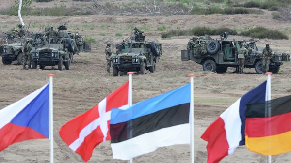 Flags wave in front of soldiers who take positions with their army vehicles during the NATO Noble Jump exercise on a training range near Swietoszow Zagan, Poland, Thursday, June 18, 2015 - Sputnik Afrique