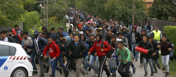 Migrants run as they follow a police vehicle on their way to the Austrian border in Nickelsdorf from Hegyeshalom, Hungary September 25, 2015. - Sputnik Afrique