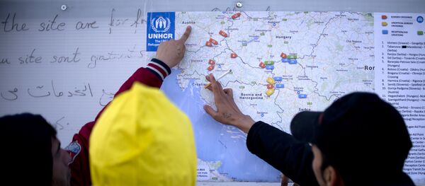 Des migrants examinent une carte des Balkans de l'Ouest, Oct. 27, 2015. - Sputnik Afrique