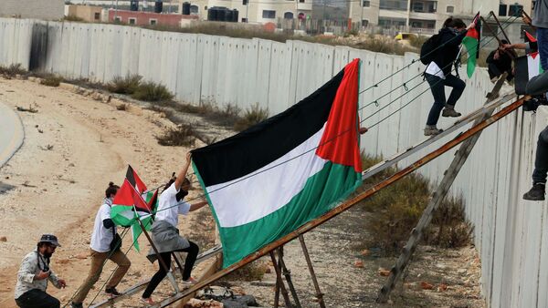 Les activistes étrangers et les manifestants palestiniens utilisent une rampe en métal pour traverser une section de la barrière israélienne controversée près du poste de contrôle Kalandia. Archive photo - Sputnik Afrique