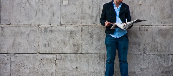 Un homme lisant un journal - Sputnik Afrique