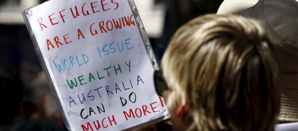 Protesters hold placards at the 'Stand up for Refugees' rally held in central Sydney. Australia is negotiating a deal with the Philippines to transfer asylum seekers being held indefinitely in controversial detention centres on remote, impoverished islands, Australia's immigration minister said on October 9, 2015 - Sputnik Afrique