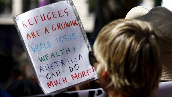 Protesters hold placards at the 'Stand up for Refugees' rally held in central Sydney. Australia is negotiating a deal with the Philippines to transfer asylum seekers being held indefinitely in controversial detention centres on remote, impoverished islands, Australia's immigration minister said on October 9, 2015 - Sputnik Afrique