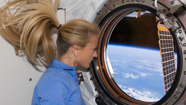 Astronaut Karen Nyberg, STS-124 mission specialist, looks through a window in the newly installed Kibo laboratory of the International Space Station while Space Shuttle Discovery is docked with the station. - Sputnik Afrique