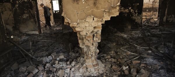 A man wearing a surgical mask walks, 14 October 2015, amongst the debris of the damaged and burnt-out MSF Trauma Centre in Kunduz, northern Afghanistan - Sputnik Afrique
