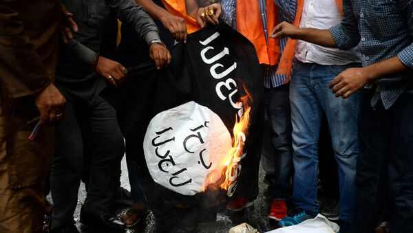 Des militants brûlent un drapeau du groupe djihadiste Etat islamique  - Sputnik Afrique