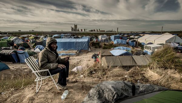 Un homme soudanais appels sa famille au Soudan, le Jungle migrants camp, Calais - Sputnik Afrique