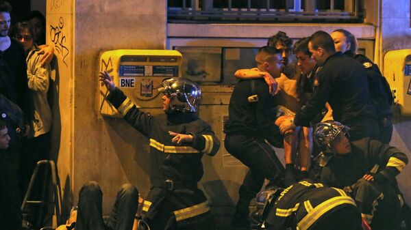 Membres de la brigade d'incendie de l'aide française un individu blessé près de la salle de concert Bataclan suivante tirs mortels à Paris, France - Sputnik Afrique