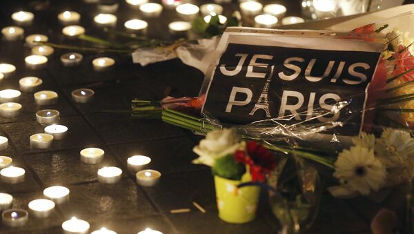 Fleurs et bougies sont placées près de la scène d'un Shootin la journée après une série d'attentats meurtriers à Paris - Sputnik Afrique