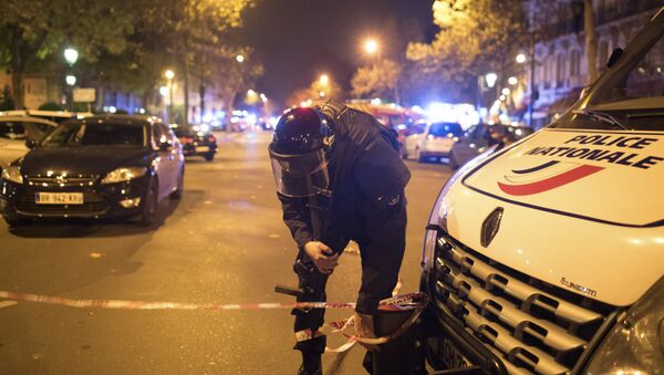 Un officier de police sécurise la zone en dehors du théâtre Bataclan à Paris, France, le mercredi 13 novembre 2015 - Sputnik Afrique