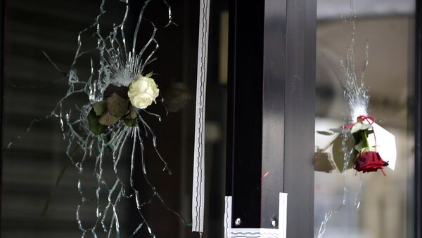 Roses are placed in bullet holes of the window of a Japanese restaurant along the Rue de Charonne in central east Paris, on November 15, 2015, two days after deadly attacks across the city - Sputnik Afrique
