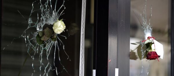 Roses are placed in bullet holes of the window of a Japanese restaurant along the Rue de Charonne in central east Paris, on November 15, 2015, two days after deadly attacks across the city - Sputnik Afrique