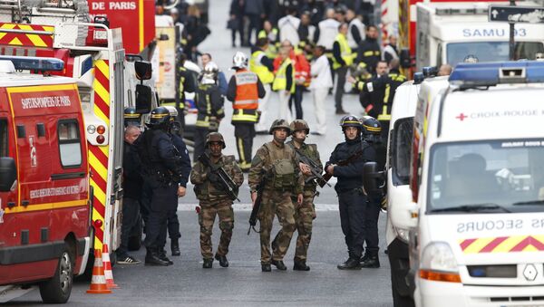 French riot police (CRS), soldiers, firefighters, French red cross members and staff of the emergency medical services in France (SAMU) stand at the scene in Saint-Denis, France, near Paris, November 18, 2015 - Sputnik Afrique