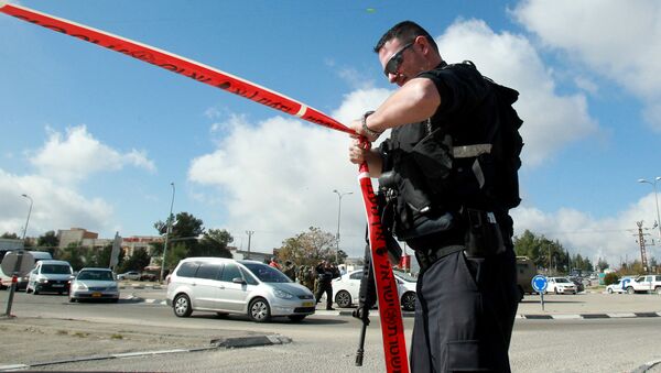An Israeli police officer holds police tape. - Sputnik Afrique