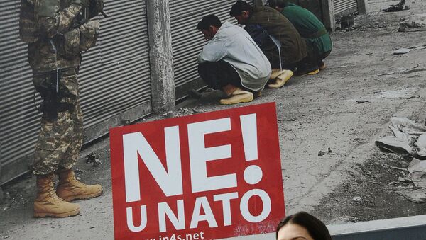 A Montenegrin woman walks past a billboard with the reading, No to NATO in Podgorica, on April 3, 2009 - Sputnik Afrique