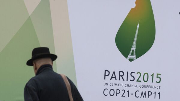 A passerby walks in front of posters for the forthcoming COP 21 World Climate Summit in Paris, France - Sputnik Afrique
